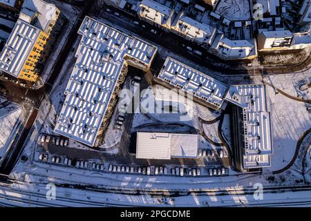 Top down aerial of residential community Ubuntuplein complex after a snow storm seen from above with roof full of solar panels covered in white Stock Photo