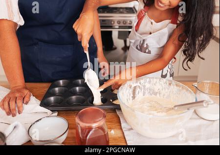 Unrecognizable granny and granddaughter making cupcakes in the kitchen Stock Photo