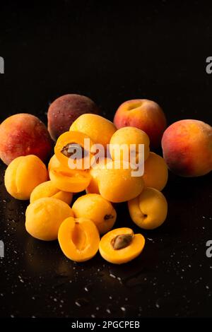 A handful of ripe apricots on a dark background. Useful fruit. Pineapple apricots on black background Stock Photo