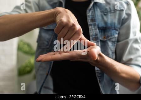 Man Using Sign Language To Communicate At Home Stock Photo