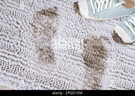 Trail of muddy footprint on gray carpet. Daily life dirty stain Stock Photo