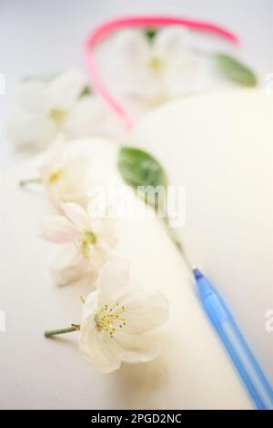 Open book with blank sheets and a pen in apple blossoms around. Inspiration concept to create or write in spring mood Stock Photo