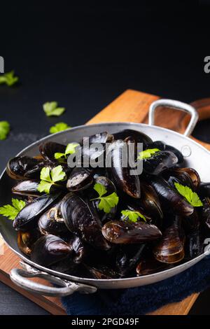 Food concept Fresh Mussels in the pan on black background with copy space Stock Photo