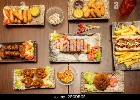Set of recipes for Cuban food, fast food and Venezuelan food, a hot dog with sauces, some teques, a tamale, battered chicken and sauces Stock Photo