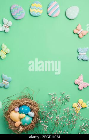 Easter banner on a green background. Easter eggs and cookies in the shape of a rabbit and a butterfly. Easter concept. Stock Photo