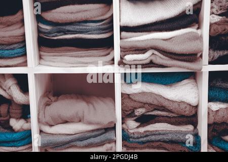 Stack of colorful  knitted colorful clothes - sweaters, dresses, cardigans etc.Toned photo. Stock Photo