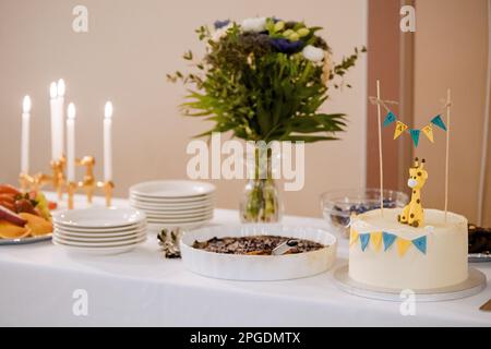 Birthday cake with giraffe and flags and flowers on the background. Stock Photo