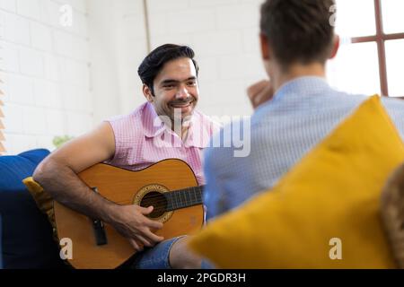 LGBTQ gay couple doing activities together at home and socializing together happily. Stock Photo