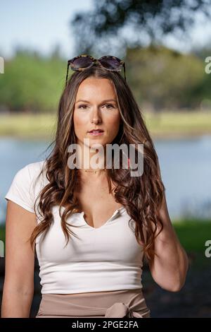 Beautiful woman posing at camera open lips and sunglasses on head Stock Photo