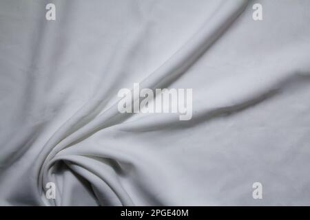 A wrinkled sheet of a white bed linen Stock Photo