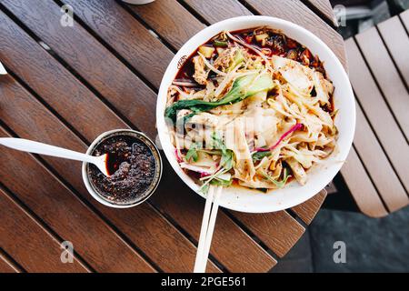 The most famous Chinese dish from Shaanxi province called biang biang noodles alternatively known as youpo chemian served with spicy chily oil chicken Stock Photo