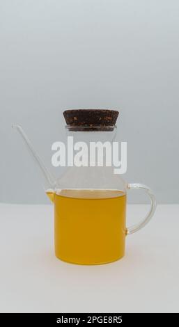 Unfiltered extra virgin olive oil in a small glass bottle isolated on a white background and close up. Stock Photo