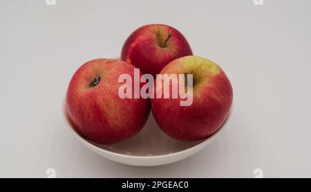 Close-up of tree small apples. The apples are in a white cup. Stock Photo