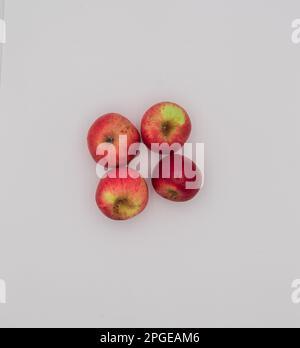 Top of view of four small red apples on white background. Stock Photo