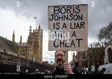 London, UK.  22 March 2023. A man with a sign outside Parliament as Boris Johnson, former Prime Minister, gives evidence to the Privileges Committee about the Partygate scandal.  Credit: Stephen Chung / Alamy Live News Stock Photo