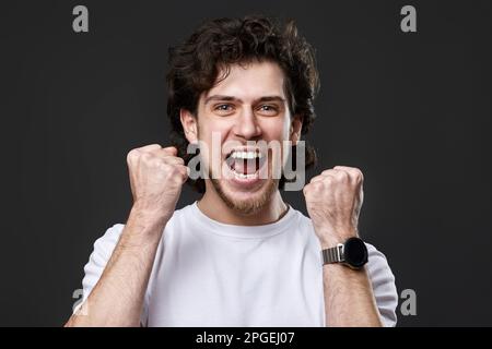 very excited young man showing victory gesture Stock Photo