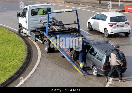 Damaged car being loaded onto a tow truck Stock Photo
