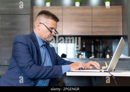 Man sitting at desk working from home on laptop. remote employee is a freelancer. Business consultant. Stock Photo