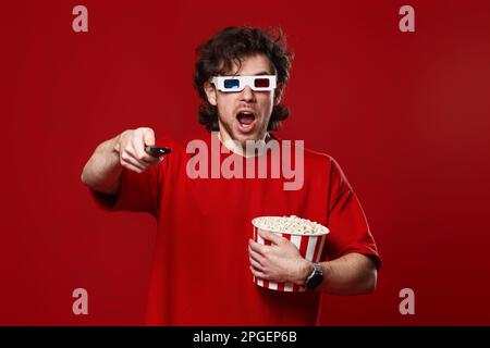 amazed shocked man in 3d glasses using remote controller Stock Photo