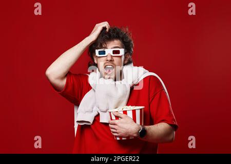 scared man in 3d-glasses holding bucket of popcorn Stock Photo