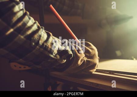 Wood Material Measuring, Marking and Cutting. Small Workshop Job. Pencil in Builders Hand Stock Photo