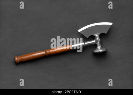 Kitchen ax with a brown wooden handle on a black background. Cleaver for cutting meat top view. Professional kitchen ax for meat with a wooden handle. Stock Photo