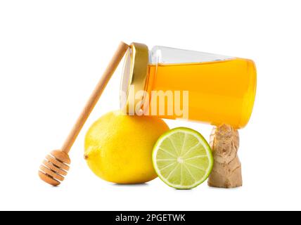 Conceptual composition of honey in a closed jar, dipper, lemon, lime and ginger on a white background. Still life of citrus fruits and honey. Stock Photo