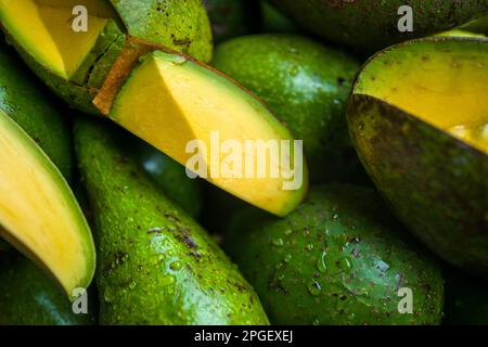 Fresh and ripe avocados, with pieces of flesh cut out to show the quality, are seen offered for sale in the street market in Ibagué, Colombia. Stock Photo