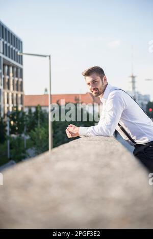 Portrait of a businessman leaning against railing, Munich, Bavaria, Germany Stock Photo