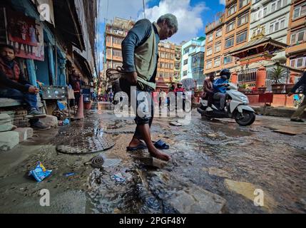 Kathmandu, Bagmati, Nepal. 22nd Mar, 2023. A man washes his feet in the flowing water after the leakage of water pipeline at the street in Kathmandu, Nepal, March 22, 2023, the World Water Day. (Credit Image: © Sunil Sharma/ZUMA Press Wire) EDITORIAL USAGE ONLY! Not for Commercial USAGE! Stock Photo