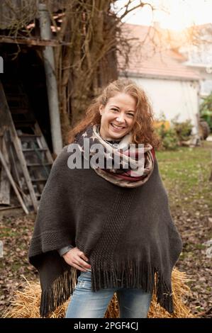 Portrait of a mid adult woman standing in the farm and smiling, Bavaria, Germany Stock Photo