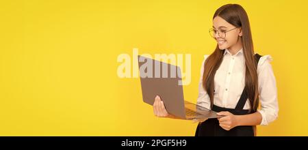 cheerful child study online. computer vision syndrome. nerd typing school blog. School girl portrait with laptop, horizontal poster. Banner header Stock Photo