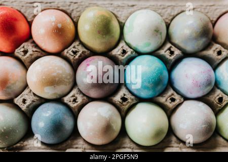 Overhead shot of close up of dyed Easter eggs in egg carton Stock Photo
