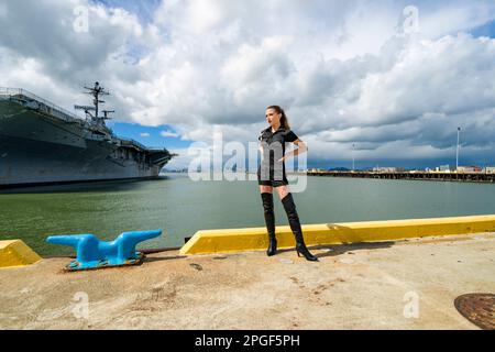 Goth Style Young Woman Standing in front of USS Hornet Stock Photo