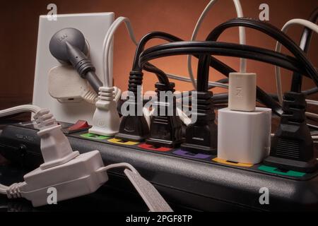 Electrical outlets and power strip overloaded beyond capacity Stock Photo