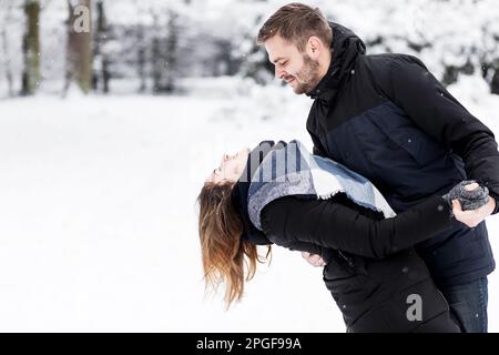 Loving couple dancing in the snowy park Stock Photo