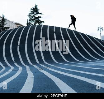 person walking between the lines of the Superkilen park Stock Photo