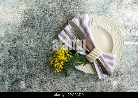Easte dinner set with yellow mimosa flowers Stock Photo