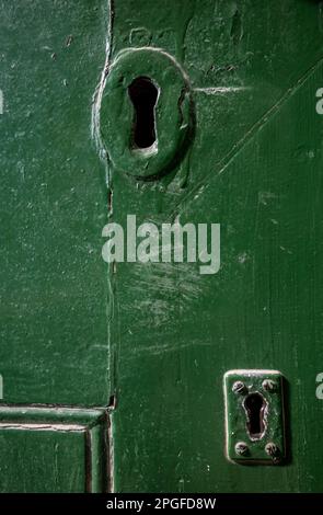 color image of two key holes on an old green wooden door Stock Photo