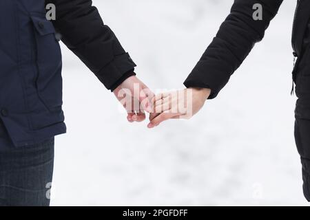 Man and woman holding hands in winter Stock Photo