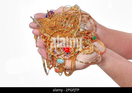 Horizontal shot of a two handfuls of gold jewelry isolated on white with copy space. Stock Photo