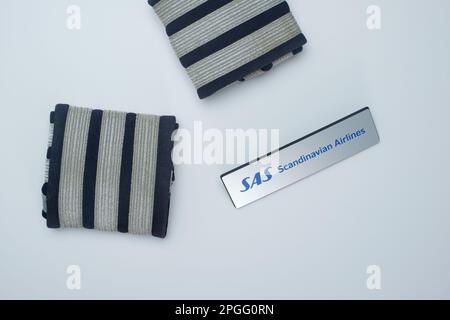 Helsinki / Finland - MARCH 23, 2023, Flatlay closeup of first officer epaulets and an aviator badge. Scandinavian Airlines System SAS Stock Photo