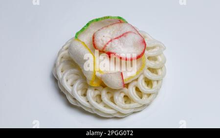 Kerupuk putih or kerupuk kaleng is Indonesian traditional crackers, isolated on white background with colorful cracker on top - white crackers from in Stock Photo