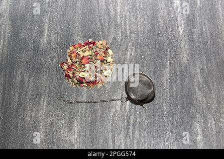 Tools for the preparation of herbal tea: glass cup, infuser, spoon, dehydrated, dried herb and sachets Stock Photo