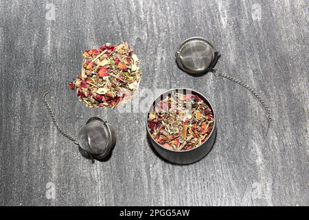 Tools for the preparation of herbal tea: glass cup, infuser, spoon, dehydrated, dried herb and sachets Stock Photo