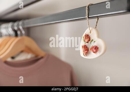 Scented sachet with flowers and stylish clothes on hanger Stock Photo -  Alamy