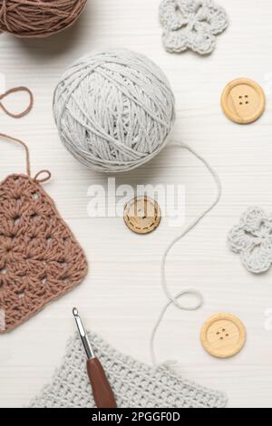 Flat lay composition with knitting threads and crochet hook on white wooden table Stock Photo