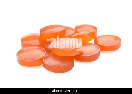 Many orange cough drops on white background Stock Photo