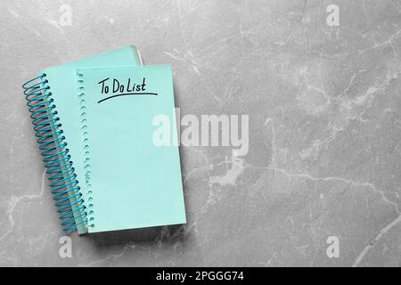 Notepad and torn sheet with inscription To Do List on light grey marble table, top view. Space for text Stock Photo
