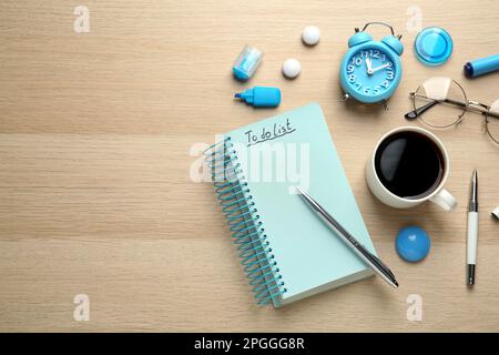 Flat lay composition with unfilled To Do list and cup of coffee on wooden table. Space for text Stock Photo